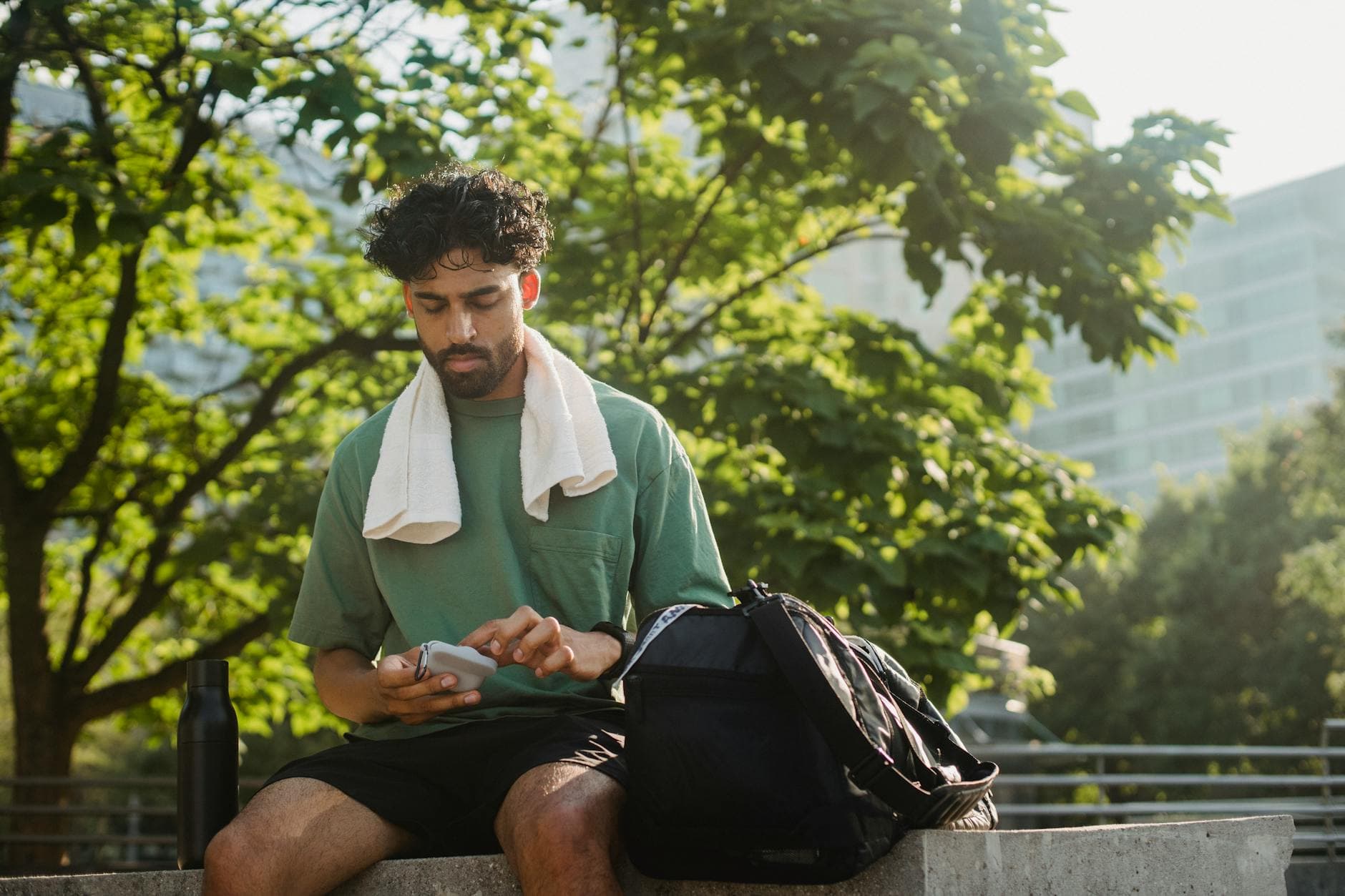 Person checking phone outdoors on a bright morning