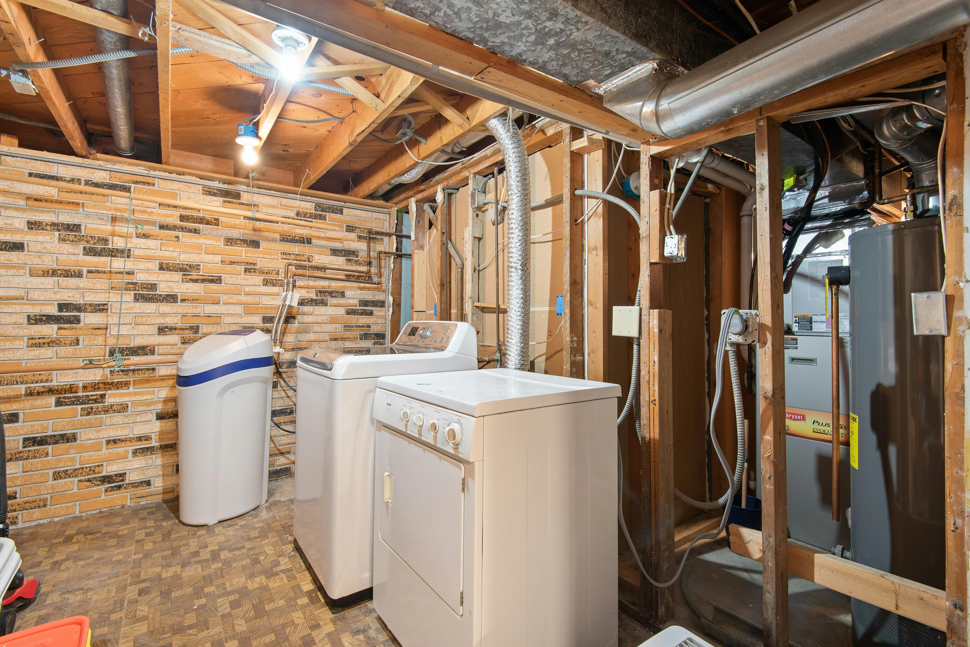 Wall-mounted residential furnace with clean ductwork in a tidy basement utility area